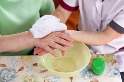 caregiver washing elder's hand