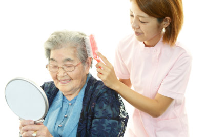 nurse combing elderly woman
